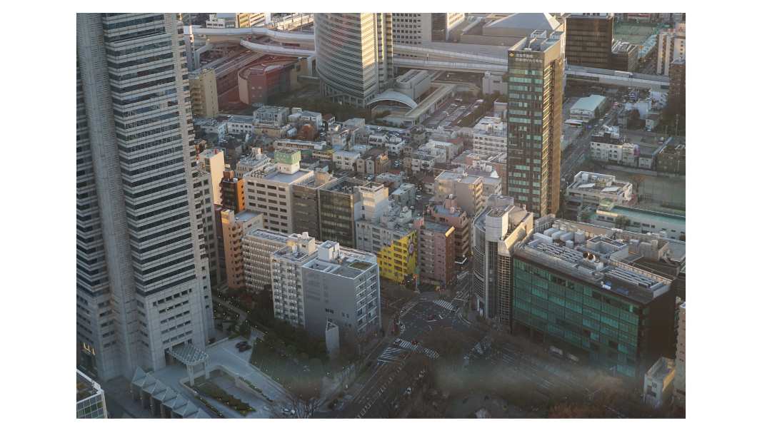 evening light spilling onto tokyo buildings as seen from a viewing platform above.